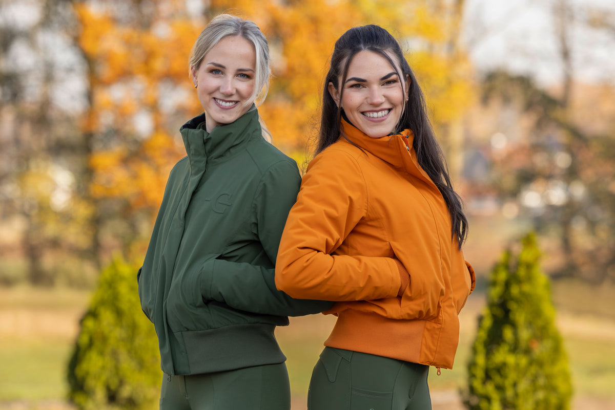 Deux cavalières en blouson d'hiver vert forêt et orange, en automne