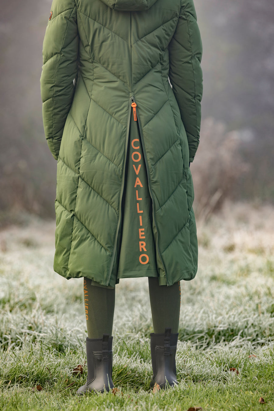 La fente arrière à fermeture éclair et le logo réfléchissant du manteau