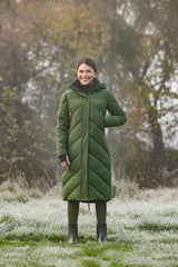 Cavalière en manteau d'hiver long vert forêt, dans un pré givré
