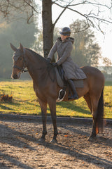 Cavalière à cheval en manteau d'hiver chocolat au lait, qui descend sur la selle