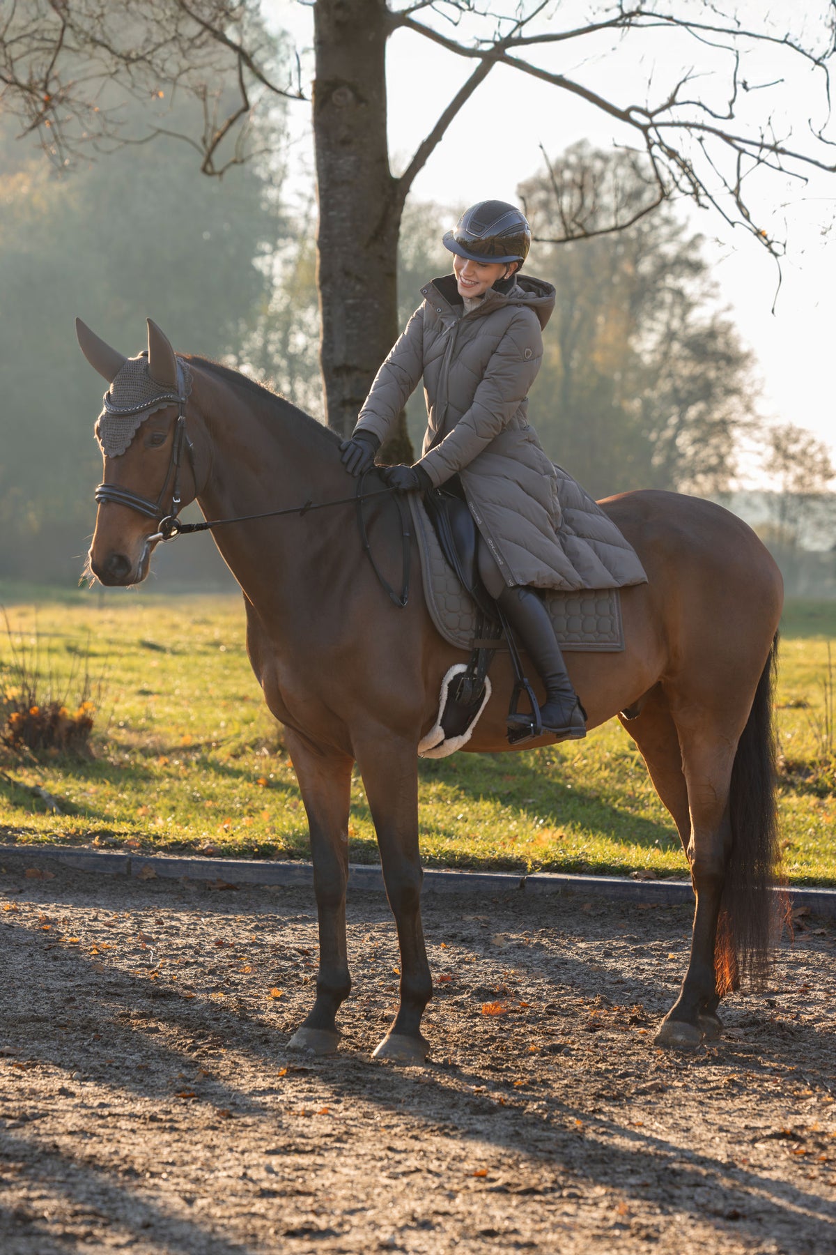 Cavalière à cheval en manteau d'hiver chocolat au lait, qui descend sur la selle