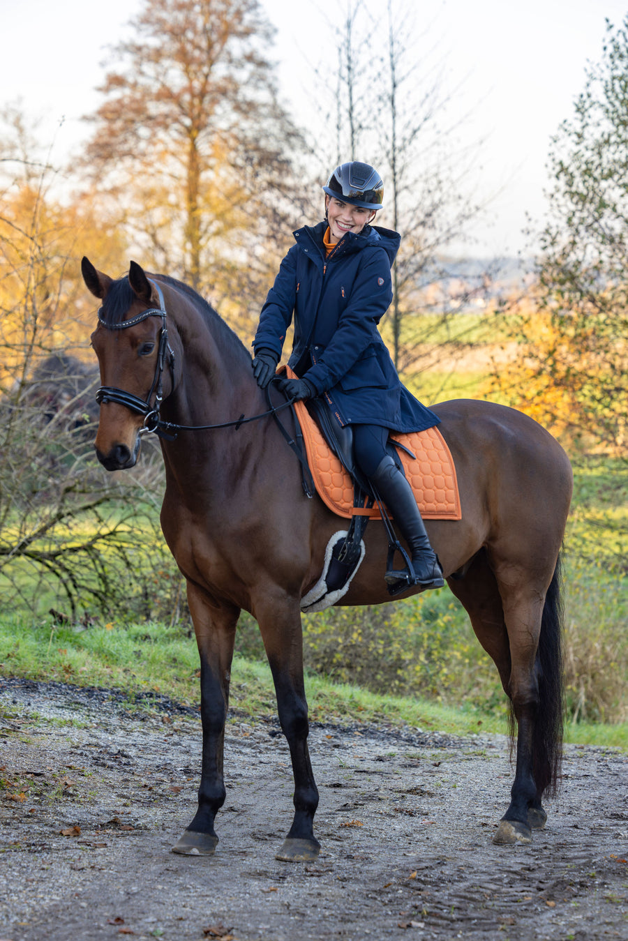Cavalière à cheval en parka bleu marine, en automne